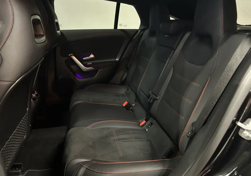 Vue intérieure côté droit des sièges arrière en cuir noir avec surpiqûres rouges d'une Mercedes CLA Shooting Brake 2024.