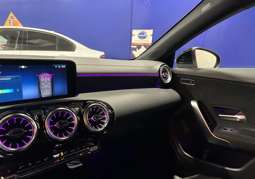 Intérieur côté passager de la Mercedes Classe CLA Shooting Brake II 200D AMG noir métallisé avec éclairage d'ambiance violet.