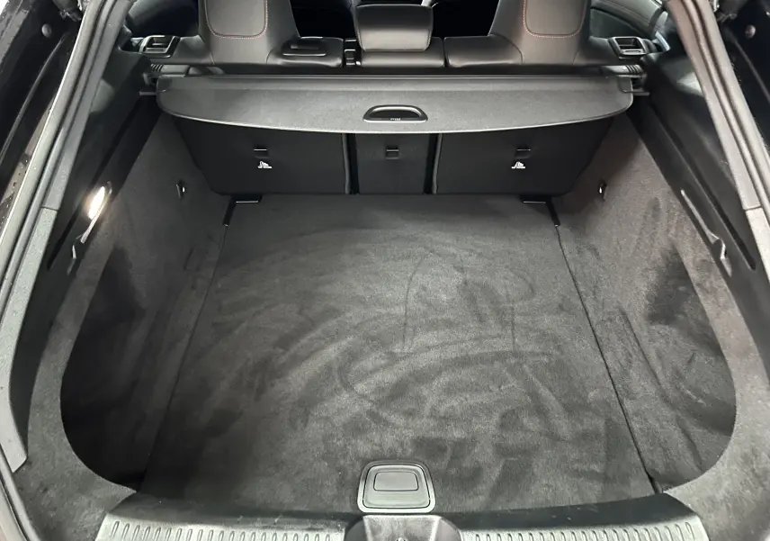 Coffre spacieux et propre de la Mercedes Classe CLA Shooting Brake II 200D AMG noir métallisé vu de l'arrière ouvert.