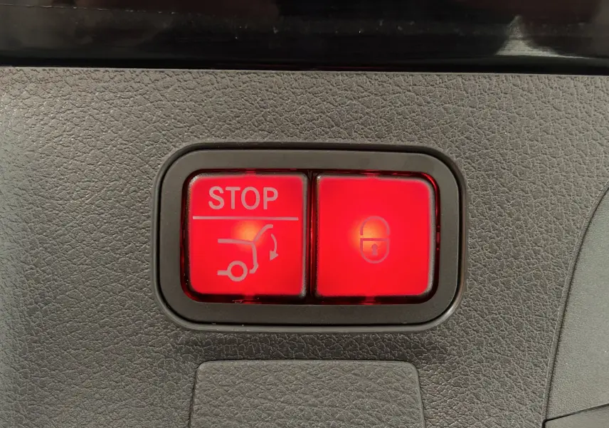 Boutons rouges lumineux pour arrêt hayon et verrouillage, sur panneau intérieur de Mercedes Classe CLA Shooting Brake noir métallisé 2024.