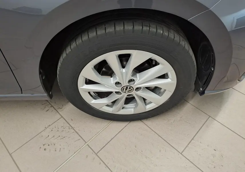 Gros plan sur la roue avant droite d'une Volkswagen Polo gris cendré 2023 avec jante alliage et peinture métallisée.