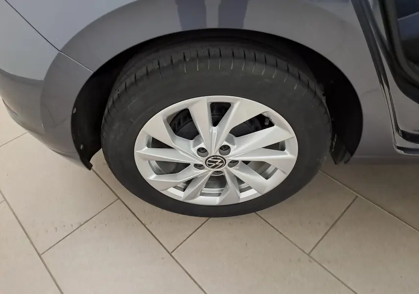 Gros plan sur la roue avant droite d'une Volkswagen Polo gris cendré avec jante alliage au design moderne.