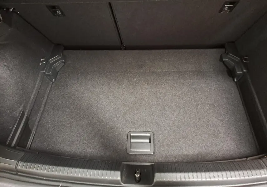 Coffre vide vu de dessus d'une Volkswagen Polo 2023 gris cendré avec tapis de sol gris foncé.