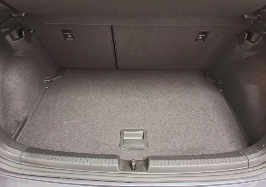 Coffre ouvert vu de dessus d’une Volkswagen Polo gris cendré 2023, montrant un espace de rangement propre et vide.