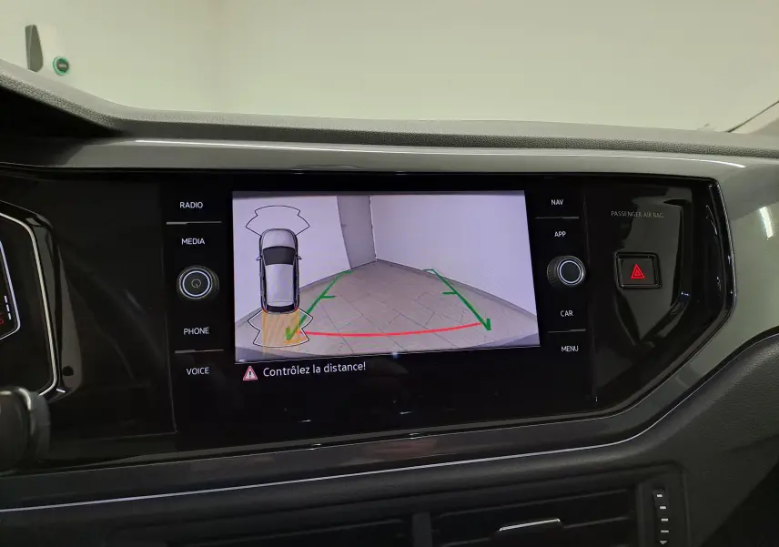 Vue rapprochée de l'écran central affichant la caméra de recul de la Volkswagen Polo gris cendré 2023.