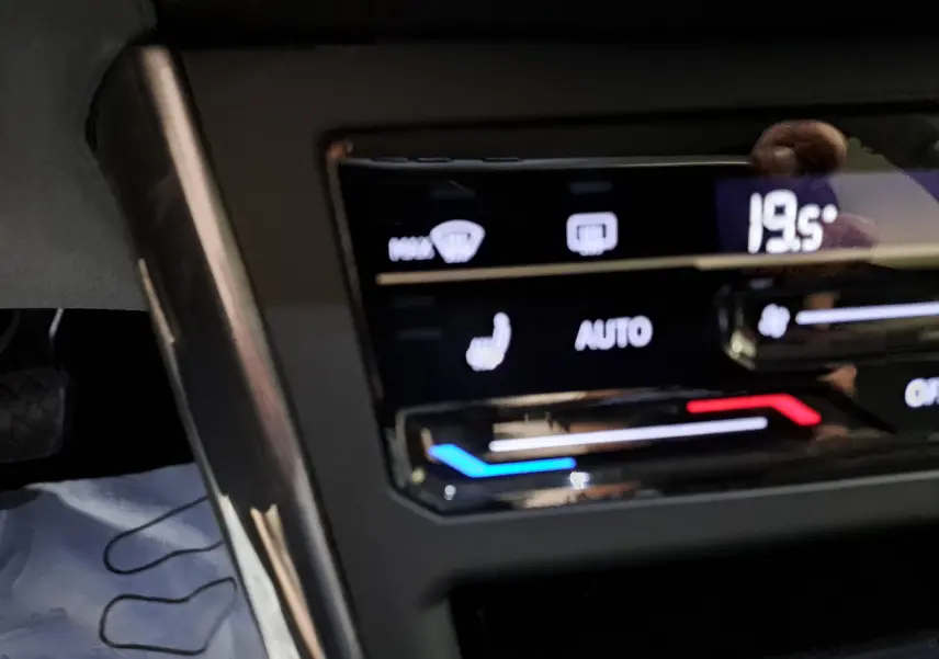 Gros plan sur la commande de climatisation digitale de la Volkswagen Polo gris cendré, affichant 19,5°C et réglages automatiques.