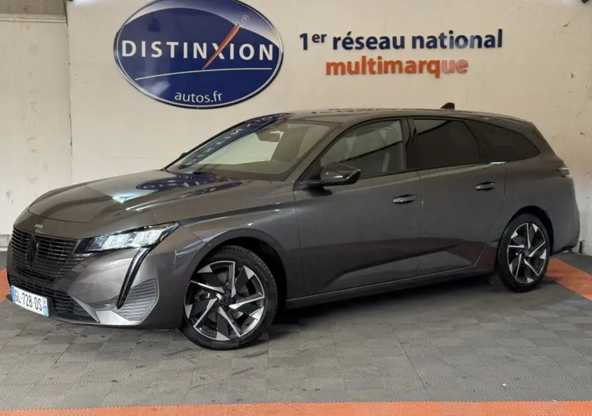 Peugeot 308 SW gris foncé vue de profil droit en intérieur, avec jantes alliage et feux LED distinctifs.