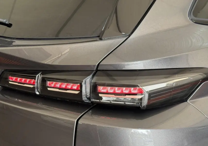 Gros plan sur les feux arrière rouges du côté gauche d’un Peugeot 308 SW gris foncé 2022.