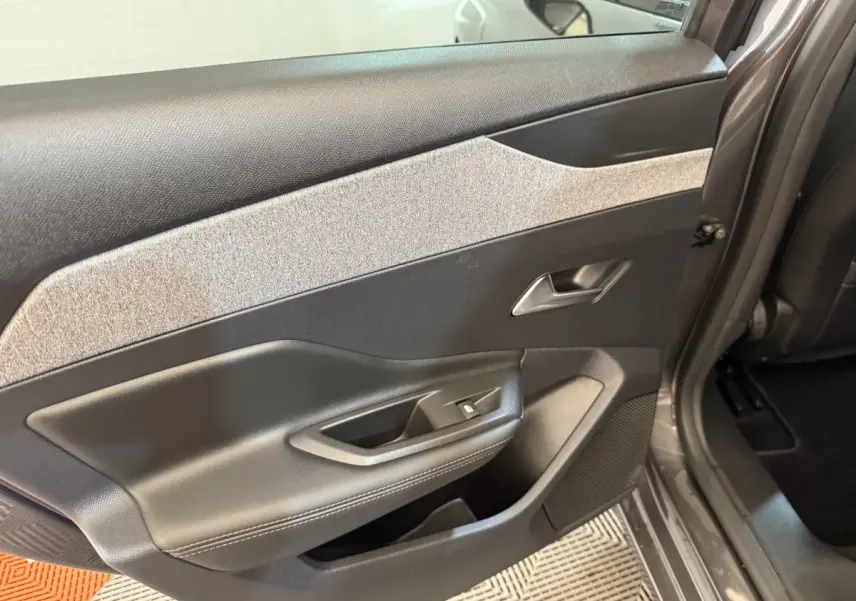 Vue rapprochée de la porte arrière droite gris foncé de la Peugeot 308 SW avec habillage noir et gris clair texturé.