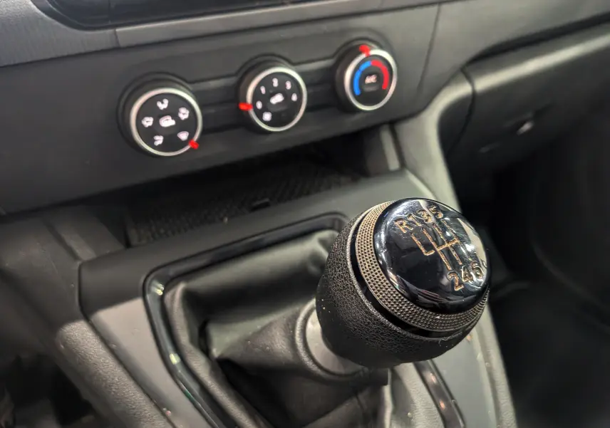Gros plan sur le levier de vitesses manuel noir du Renault Kangoo 2021, avec commandes de climatisation en arrière-plan.