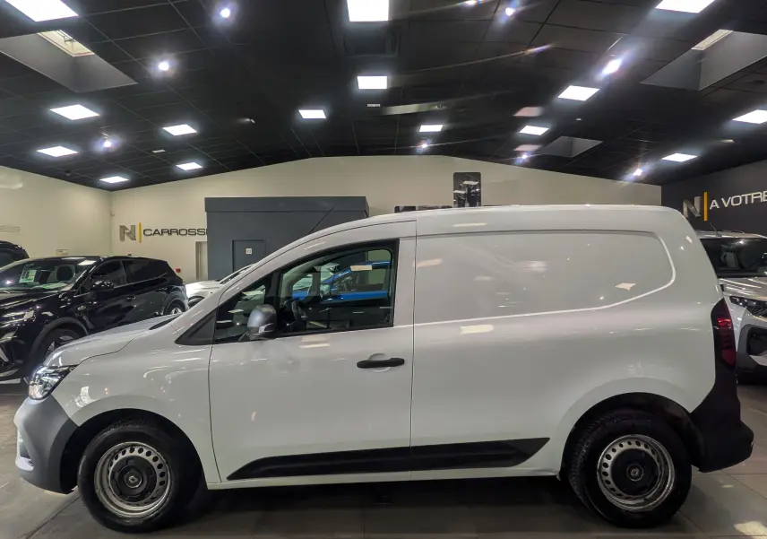 Profil latéral droit du Renault Kangoo Van blanc minéral 2021, avec jantes acier et détails noirs sur les bas de caisse.