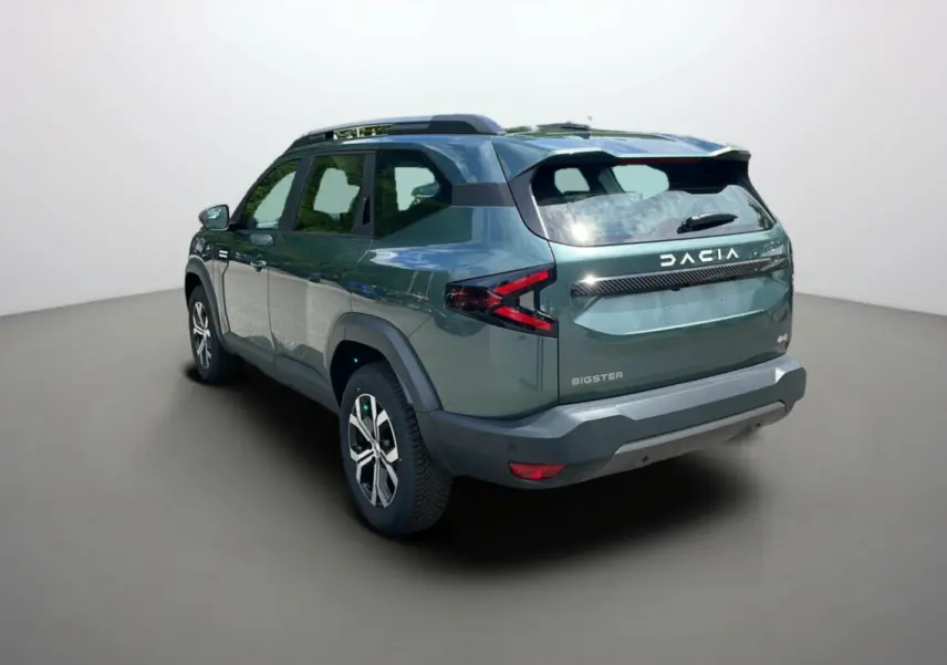 Vue 3/4 arrière droite du Dacia Bigster vert cèdre avec barres de toit et jantes alu 17 pouces visibles.
