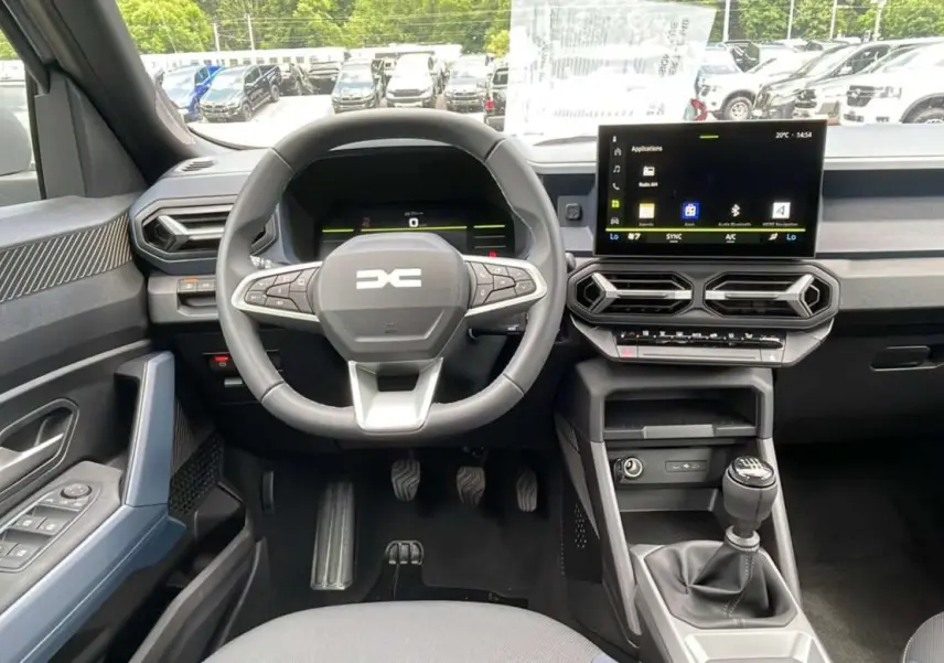 Vue intérieure frontale du tableau de bord du Dacia Bigster 2025, volant cuir et écran tactile central visible.