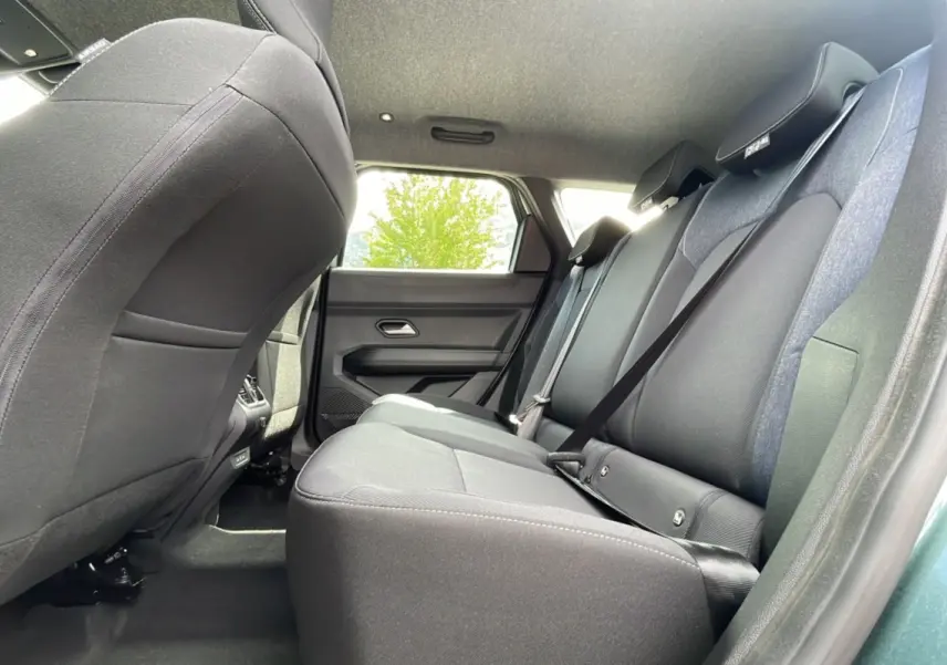 Vue intérieure arrière côté droit du Dacia Bigster 2025, sièges tissu gris et ceinture de sécurité visible.