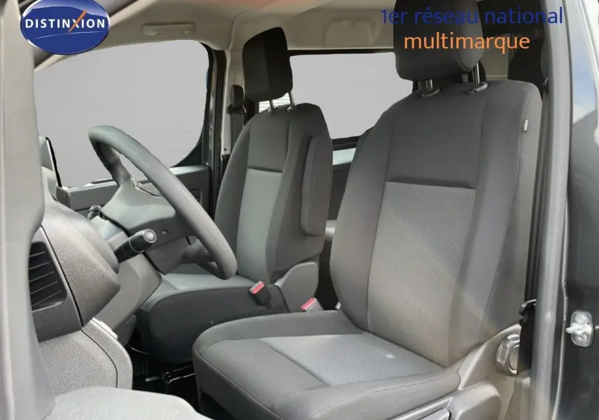 Vue intérieure côté conducteur du Citroën Jumpy Cabine Approfondie gris titane, sièges en tissu gris et volant multifonction.