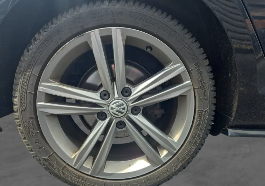 Gros plan sur la roue avant droite d'une Volkswagen Golf noire 2019, jante alliage R-line à 5 doubles branches.