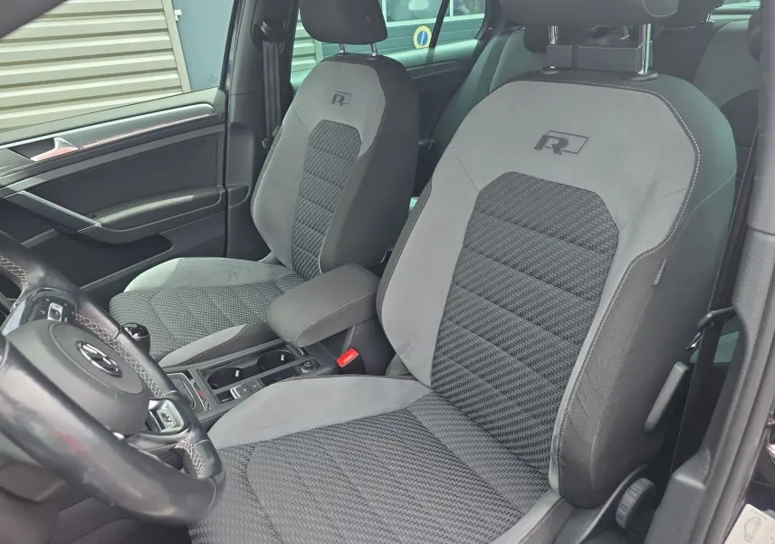 Vue intérieure rapprochée des sièges avant gris avec logo R de la Volkswagen Golf 1.5 TSI EVO 150 R-line noire de 2019.