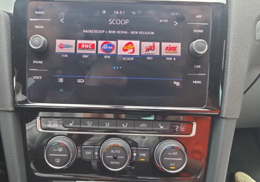 Vue rapprochée de la console centrale d’une Volkswagen Golf noire 2019, avec écran tactile et commandes de climatisation.