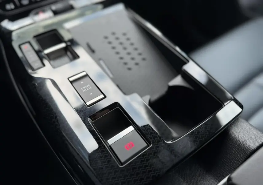 Gros plan sur la console centrale noire brillante du Citroën C5 Aircross avec bouton frein électrique et sélecteur mode conduite.