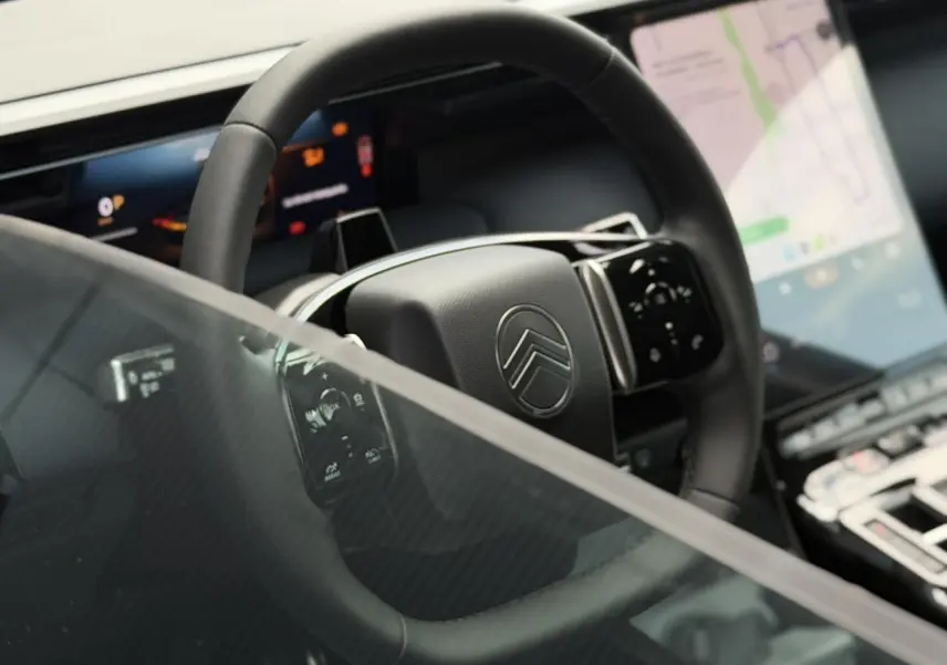 Vue rapprochée du volant noir multifonctions de la Citroën C5 Aircross avec écran tactile et affichage numérique.