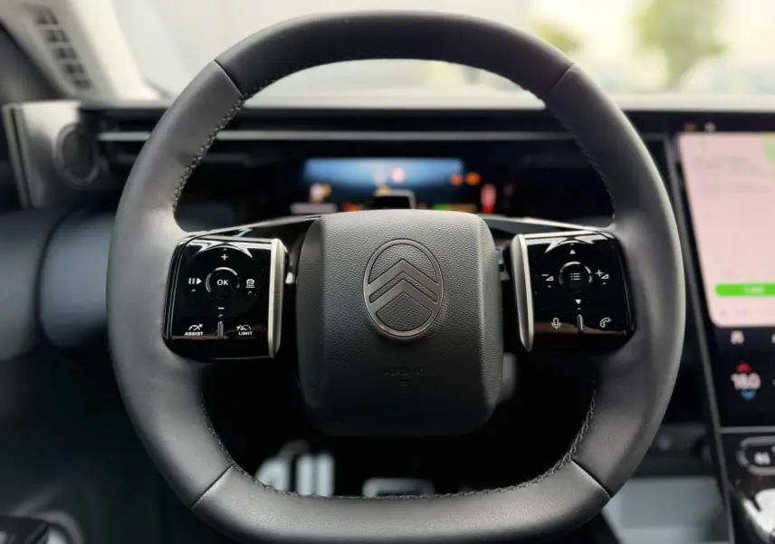 Gros plan sur le volant noir multifonctions de la Citroën C5 Aircross 2026 avec palettes au volant et logo central.