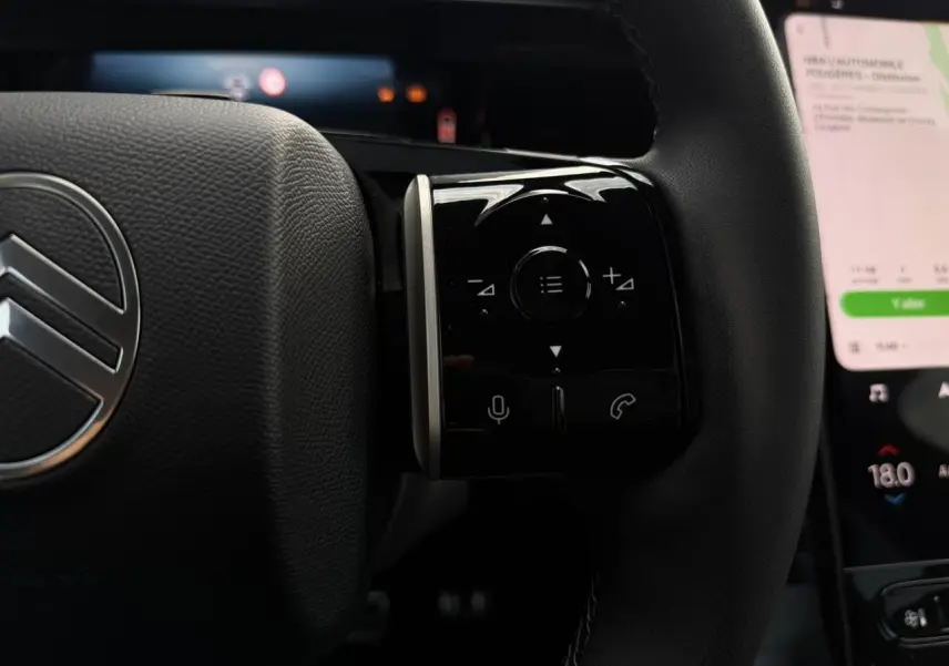 Gros plan sur le volant noir du Citroën C5 Aircross 2026 avec commandes tactiles et logo chromé visible.