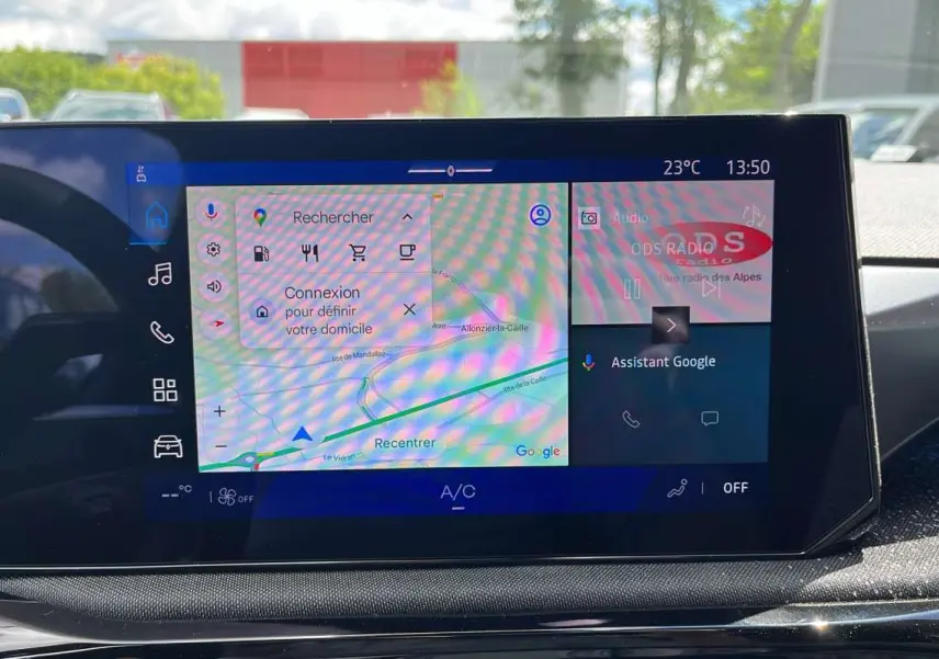 Écran tactile central de la Renault Clio 6 TCE 115 EDC Techno affichant la navigation Google et la radio, intérieur noir.