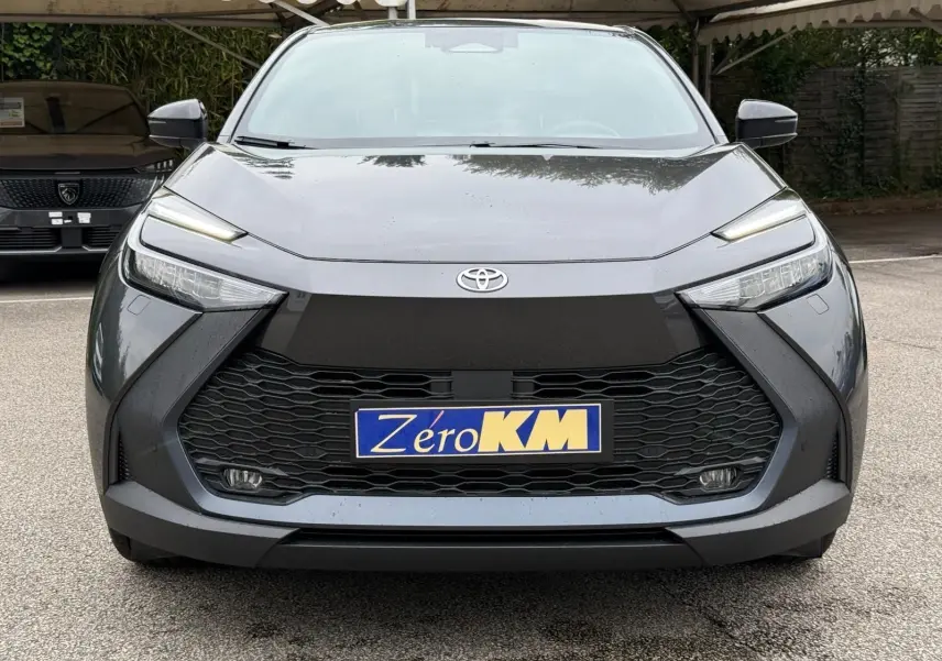 Vue frontale du Toyota C-HR 1.8 140CH STYLE gris atlas avec calandre noire et phares LED fins.