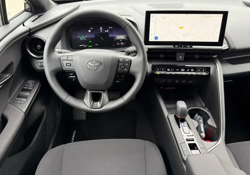 Vue intérieure du poste de conduite du Toyota C-HR 1.8 140CH STYLE MY25 avec écran tactile et volant multifonction.