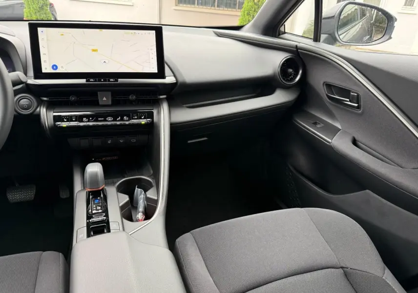 Intérieur du Toyota C-HR 1.8 140CH STYLE 2025, vue côté passager avec écran tactile et console centrale moderne.