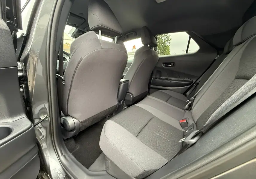 Vue intérieure arrière côté gauche du Toyota C-HR 1.8 140CH STYLE gris atlas, sièges tissu bicolore gris et noir.