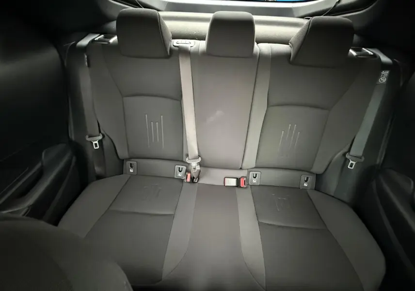 Vue arrière intérieure des sièges arrière noirs du Toyota C-HR 1.8 140CH STYLE MY25, tissus et ceintures visibles.