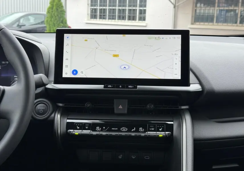 Tableau de bord du Toyota C-HR 1.8 140CH STYLE 2025 avec écran tactile GPS et commandes climatisation affichant 19°C.