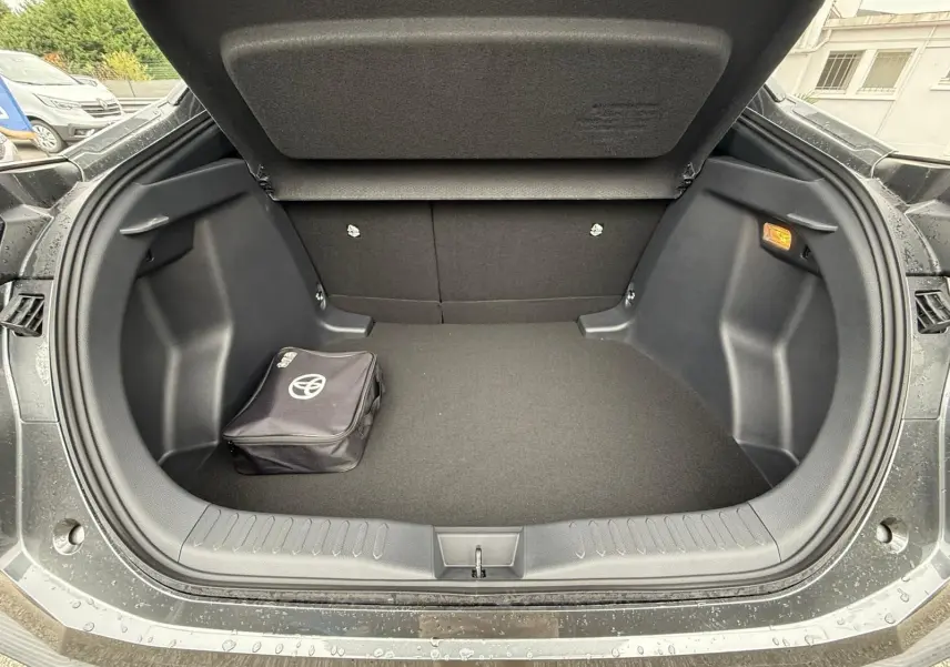 Coffre ouvert du Toyota C-HR gris atlas 2025 montrant un sac de secours noir avec logo Toyota.