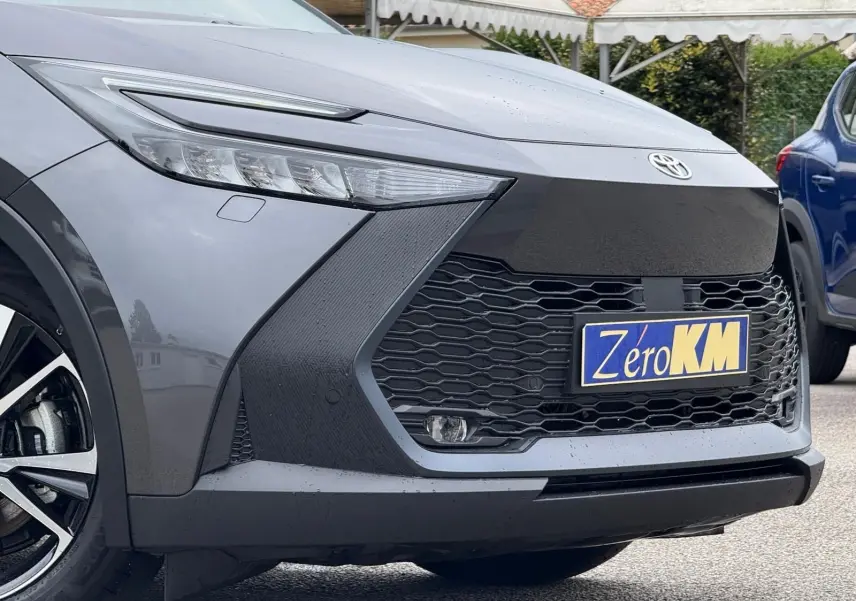 Vue rapprochée 3/4 avant gauche du Toyota C-HR 1.8 140CH STYLE gris atlas avec calandre noire et phares LED fins.