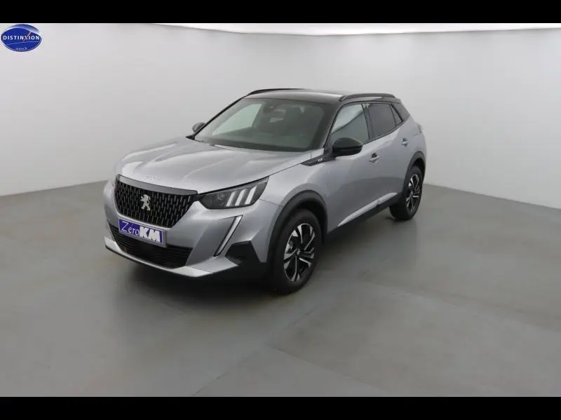 Peugeot 2008 gris Artense vue 3/4 avant droit dans un studio avec toit noir et jantes alu noires.