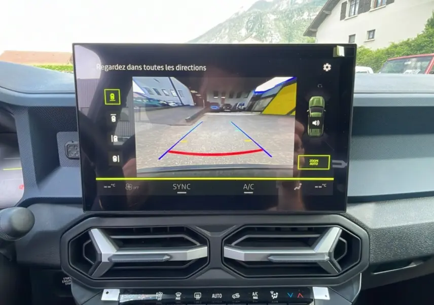 Écran central affichant la caméra multiview du Dacia Bigster, intérieur noir avec aérateurs hexagonaux visibles.