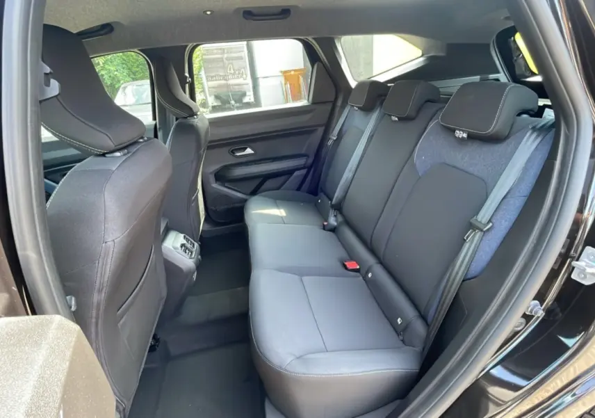 Vue intérieure côté droit sur la banquette arrière noire et grise du Dacia Bigster noir perle 2025, avec ceintures et appuie-têtes.