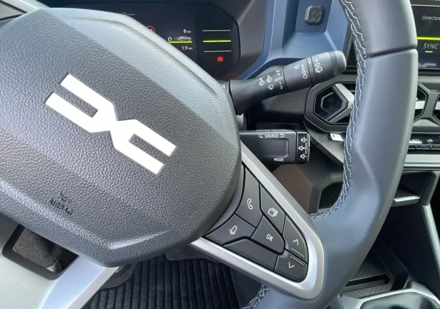 Gros plan sur le volant cuir noir du Dacia Bigster 2025 avec commandes intégrées et tableau de bord partiel visible.