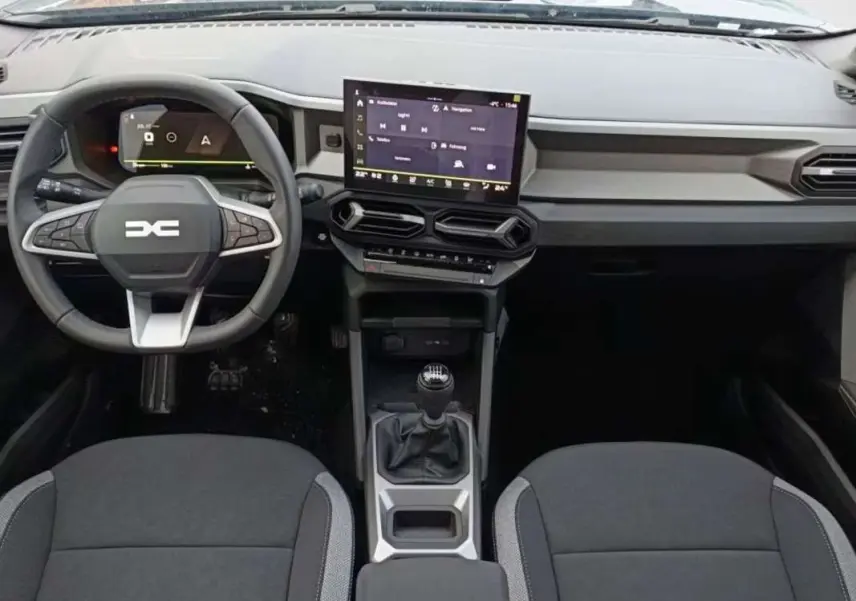 Vue intérieure frontale du tableau de bord et volant cuir noir du Dacia Bigster avec écran tactile central et boîte manuelle.