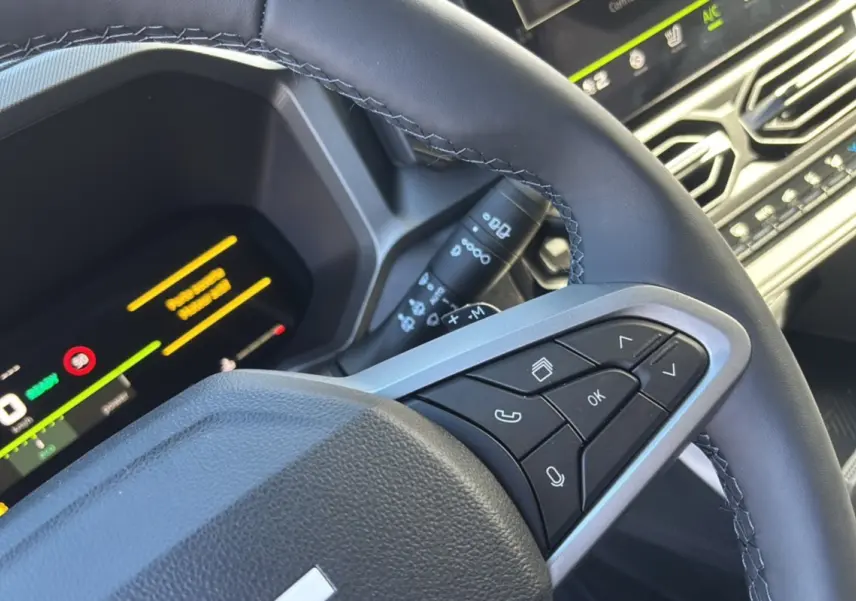 Gros plan sur le volant cuir noir côté droit du Dacia Bigster 2026 avec commandes multifonctions et tableau de bord digital.