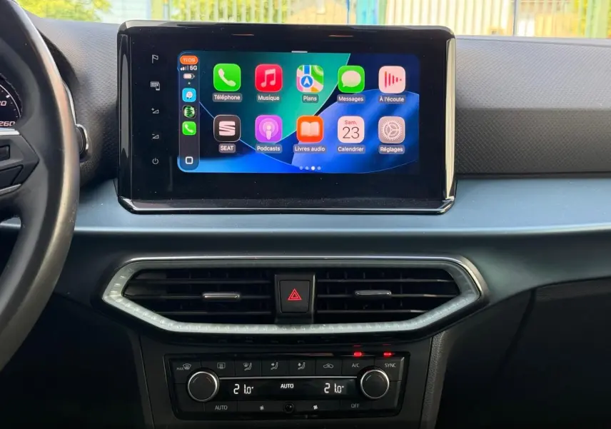 Vue intérieure frontale du tableau de bord du SEAT Arona 2022 avec écran tactile central affichant Apple CarPlay.