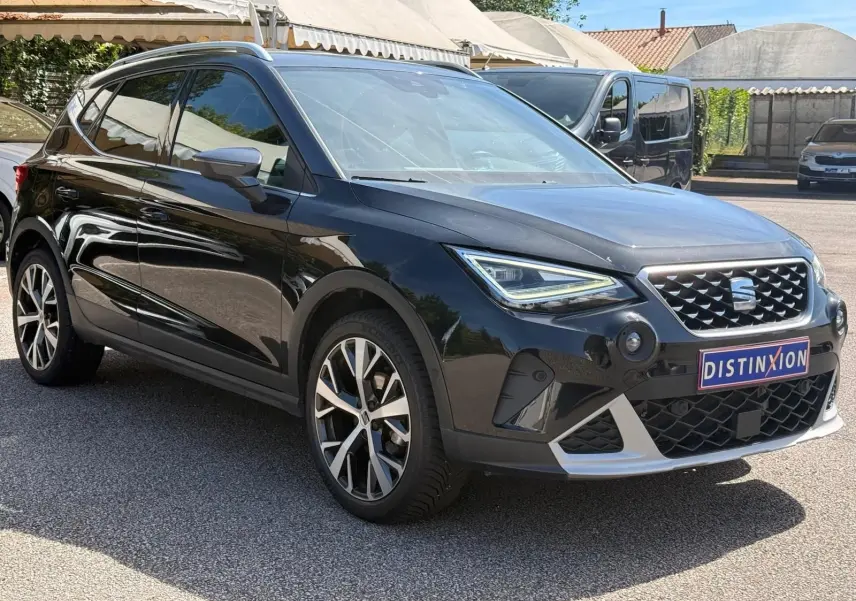 Vue 3/4 avant droite d'une SEAT Arona noire avec jantes alliage et calandre distinctive FR Xclusive.
