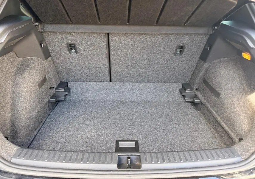 Vue intérieure du coffre gris du SEAT Arona 2022, montrant l'espace de rangement et la moquette intégrale.
