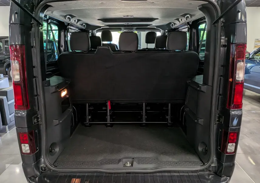 Vue arrière ouverte du Nissan Primastar Combi gris Comète 2025, montrant l'espace intérieur et les sièges arrière.