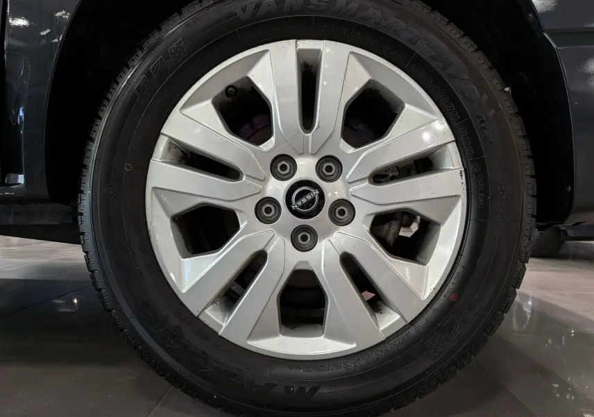 Gros plan sur la roue avant droite du Nissan Primastar Combi gris Comète, jante alliage avec logo Nissan central.