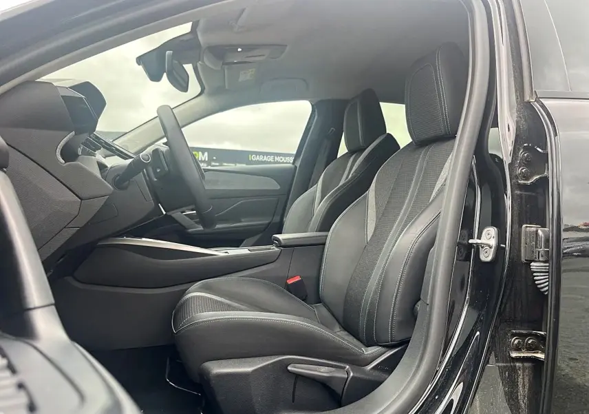 Intérieur de la Peugeot 308 1.5 BlueHDi 130 noir, vue côté gauche sur les sièges avant en tissu gris avec surpiqûres quartz.