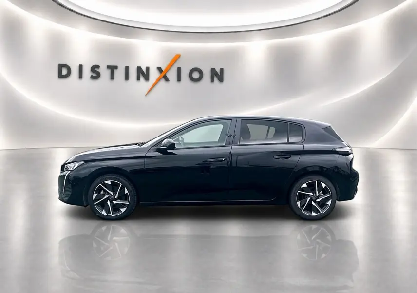 Profil droit d'une Peugeot 308 noire 2025 avec jantes alliage et lignes épurées dans un showroom lumineux.