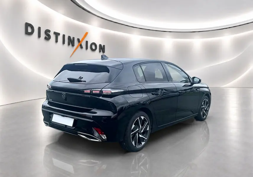Peugeot 308 noire vue 3/4 arrière droit dans un showroom lumineux avec jantes alliage distinctives.