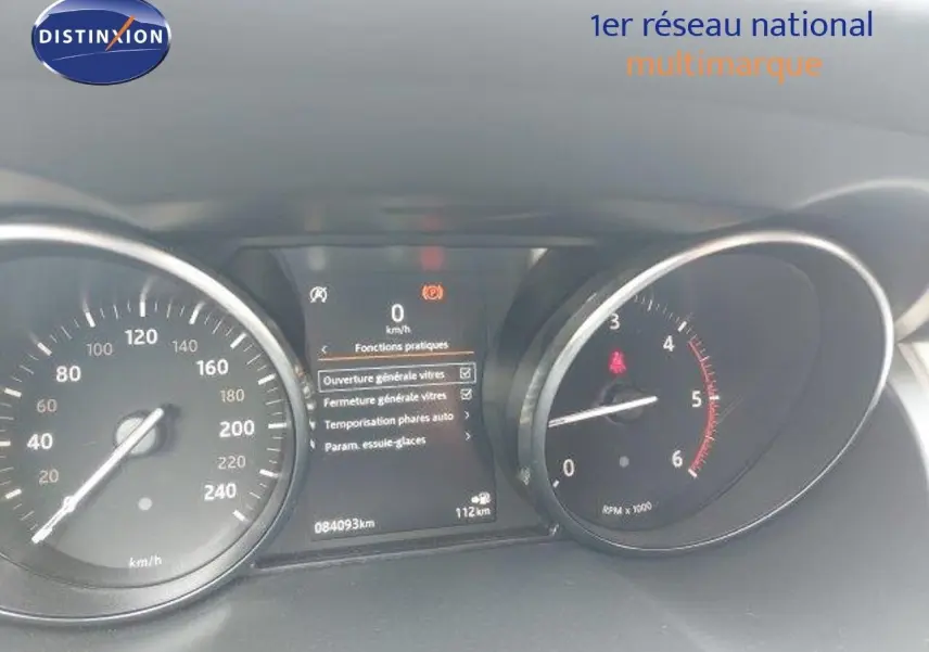 Tableau de bord du Range Rover Evoque blanc 2018, affichant vitesse, compte-tours et menu des fonctions pratiques.